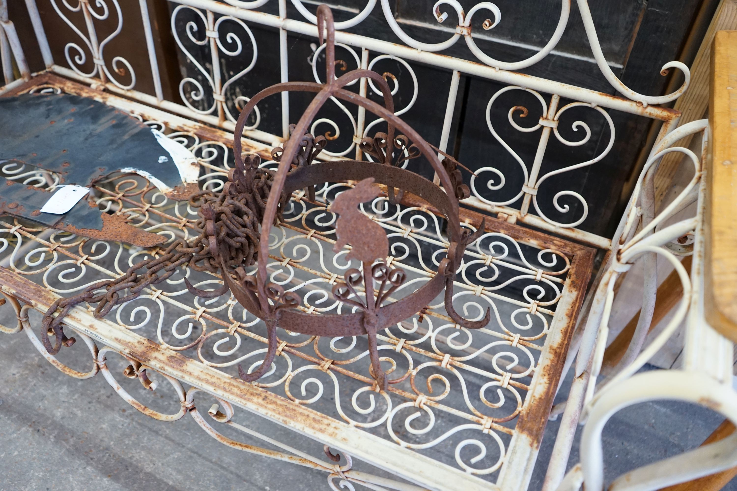 A circular wrought iron pot hanger together with a painted metal 'badger' weather vane, length 58cm